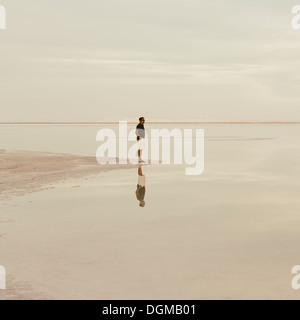 Un homme debout au bord de la Bonneville Salt Flats inondées de soleil. Banque D'Images