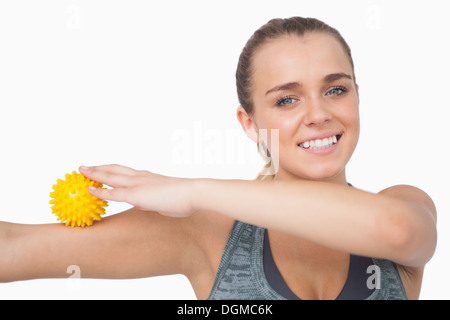 Cheerful young woman touching bras avec balle de massage Banque D'Images