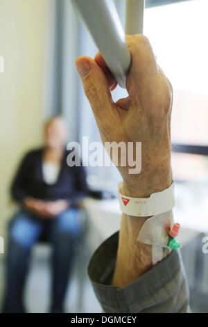 Un homme âgé dans un hôpital, détail, main tenant une poignée dans un lit d'hôpital Banque D'Images