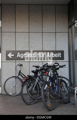 Les vélos stationnés devant le panneau "Agentur für Arbeit', l'allemand pour l'emploi, Cologne, Rhénanie Banque D'Images