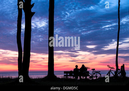 Couple assis sur un banc, silhouettes, coucher de soleil sur la mer, Rostock, Mecklembourg-Poméranie-Occidentale, Allemagne Banque D'Images