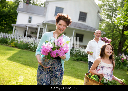 Partie de la famille. Les parents et les enfants à la réalisation des fleurs, fruits et légumes frais cueillis. La préparation pour une fête. Banque D'Images