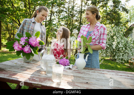 Trois personnes des fleurs et les disposer ensemble. Une femme mature, un adolescent et un enfant. Banque D'Images