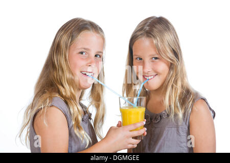 Les filles, 9 lits jumeaux, de boire le jus d'orange Banque D'Images
