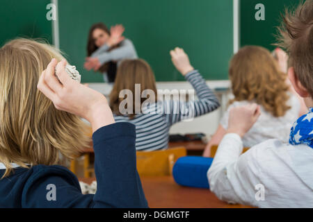 Les enfants de l'école dans une classe throwing paper balls à l'enseignant, de l'intimidation à l'encontre des enseignants, Allemagne Banque D'Images