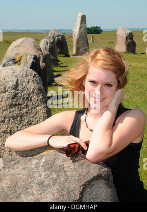 Redhaired femme à l'Ale Ales stenar ou pierres près de Kåseberga, Suède, Europe Banque D'Images