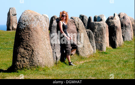 Redhaired femme à l'Ale Ales stenar ou pierres près de Kåseberga, Suède, Europe Banque D'Images