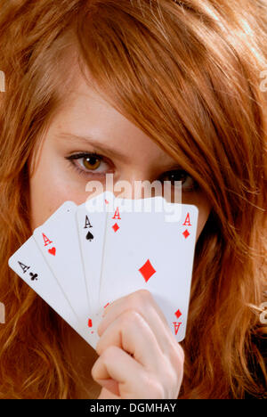 Redhaired femme montrant quatre as playcards Banque D'Images