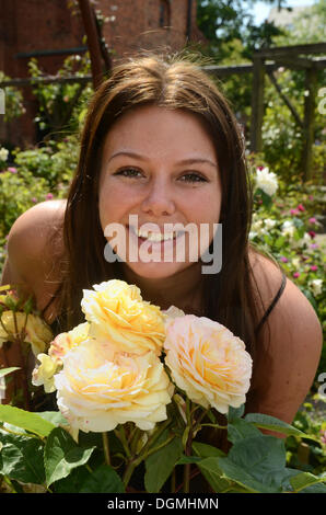 Jeune femme avec des roses à la roseraie à Ystad, Suède, Europe Banque D'Images