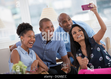 Office de l'événement. Une femme prenant une des selfies le groupe avec un smart phone rose. Banque D'Images