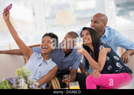 Office de l'événement. Une femme prenant une des selfies le groupe avec un smart phone rose. Banque D'Images
