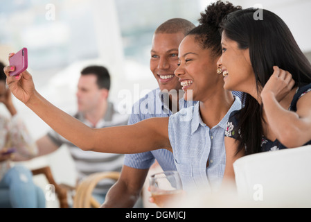 Office de l'événement. Une femme prenant une des selfies groupe avec un téléphone intelligent. Banque D'Images