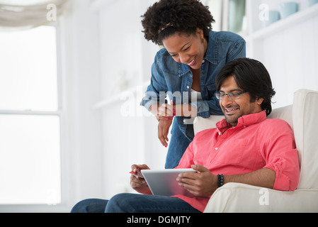 La vie de bureau. Un homme et une femme à la recherche d'une tablette numérique à. Banque D'Images