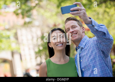 Un couple, un homme et une femme prenant une selfy avec un téléphone intelligent. Banque D'Images