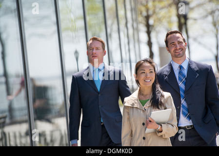 Une femme et deux hommes d'affaires à l'extérieur de la ville. Banque D'Images