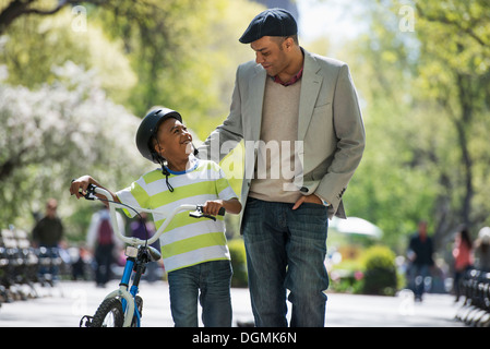 Le vélo et le plaisir. Un père et son fils, côte à côte. Banque D'Images