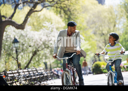 Le vélo et le plaisir. Un père et son fils, côte à côte. Banque D'Images