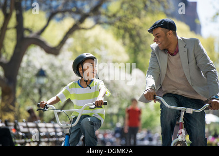 Le vélo et le plaisir. Un père et son fils, côte à côte. Banque D'Images