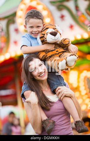 USA, Utah, Salt Lake City, mère de donner son fils (4-5) piggyback ride in amusement park Banque D'Images