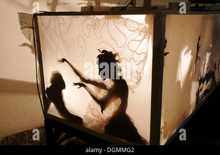 Femme envoûte un homme, projection de silhouette chiffres dans une boîte lumineuse, théâtre d'ombres, d''Académie Académie d'Art de Banque D'Images