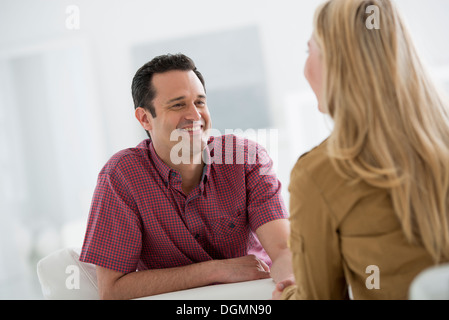 L'intérieur du bureau. Deux personnes de parler les uns aux autres, face à face. Banque D'Images