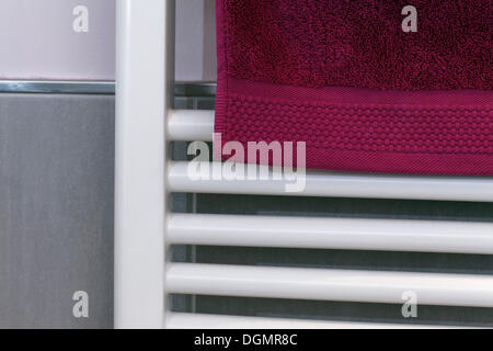 Berry-serviette de couleur accroché sur un radiateur pour sécher, salle de bains Banque D'Images