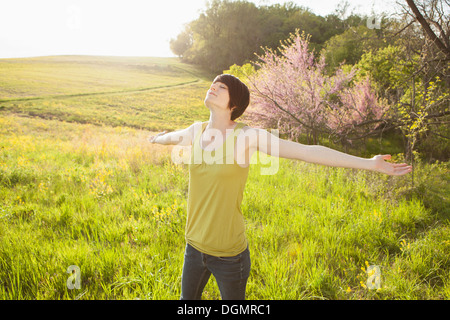 Jeune femme debout dans les champs au printemps. Banque D'Images