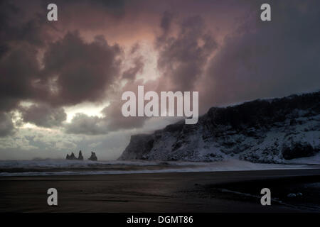 Stormy coucher du soleil sur la plage de Vik, pinacles de Reynisdrangar, Sud de l'Islande, Islande, Europe Banque D'Images