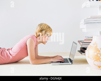 Young woman using laptop, studio shot Banque D'Images