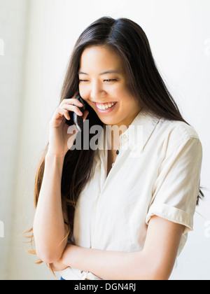 Smiling young woman talking via téléphone mobile Banque D'Images