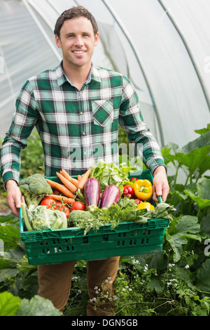 Jeune homme présentant fièrement quelques légumes Banque D'Images