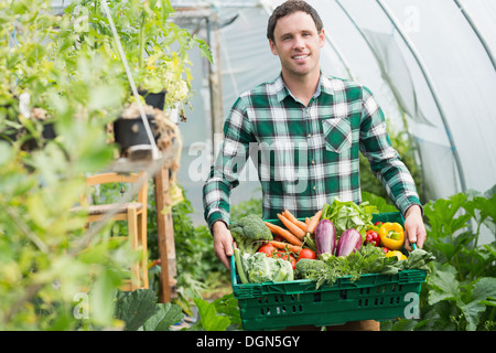 L'homme orgueilleux de présenter les légumes dans un panier Banque D'Images