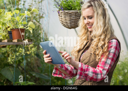 Pretty woman using her tablet dans une maison verte Banque D'Images