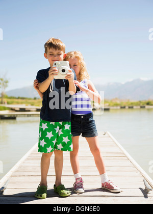 USA, Utah, Salt Lake City, deux enfants (4-5, 6-7) holding camera on pier Banque D'Images