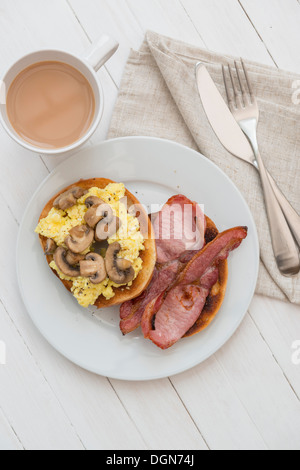 Œufs, bacon et champignons bagel, avec une tasse de thé. Banque D'Images