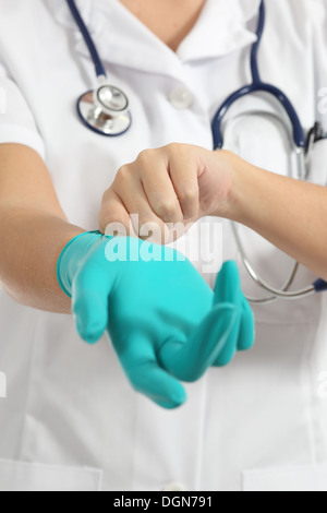 Gros plan d'une femme médecin de mettre des gants en latex isolé sur fond blanc Banque D'Images