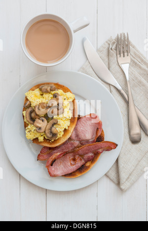 Œufs, bacon et champignons bagel, avec une tasse de thé. Banque D'Images