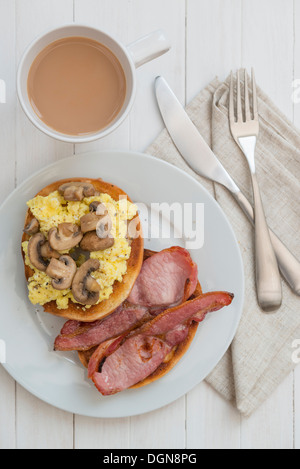 Œufs, bacon et champignons bagel, avec une tasse de thé. Banque D'Images