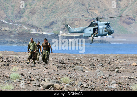 Opération spéciale nous aviateurs avec le 82e Escadron de sauvetage expéditionnaire et les soldats de la force spéciale française marcher jusqu'à la plage après avoir sauté d'un hélicoptère français SA-330 Puma pendant air-eau la formation de qualification le 17 octobre 2013, près du Camp Lemonnier, Djibouti. Banque D'Images