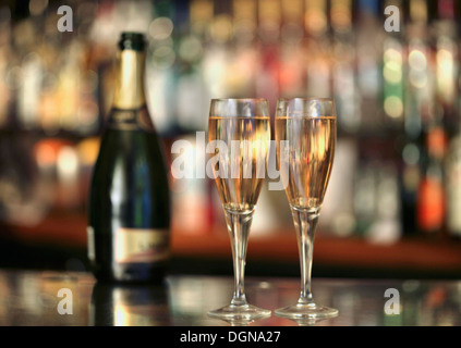 Une bouteille de champagne et deux verres de champagne sur un bar Banque D'Images