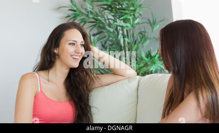 Le chat magnifique women sitting on a couch Banque D'Images