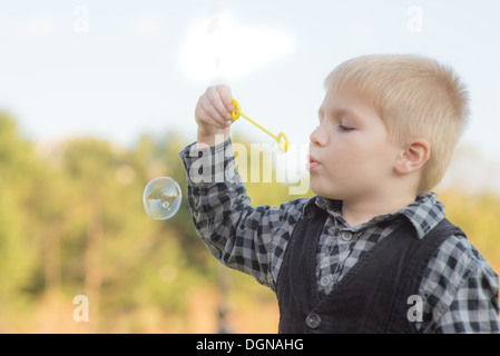 Boy blowing bubbles Banque D'Images