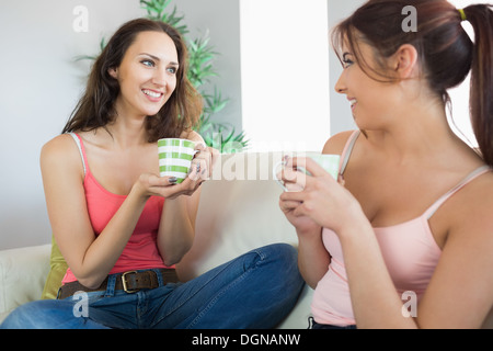 Deux jolies jeunes femmes holding tasses Banque D'Images