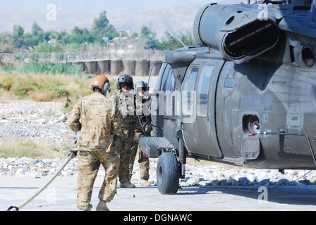 UH-60L Black Hawk helicopter crew chiefs provenant d'une société, 2e Bataillon (assaut), 10e Brigade d'aviation de combat, Task Force Phoenix, regardez sur l'approvisionnement en pétrole comme un prépare des spécialistes pour faire le plein de leurs avions à l'avant et d'armement, point de ravitaillement en oct. Banque D'Images