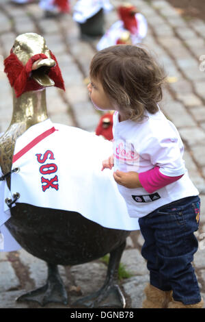 Boston, Massachusetts, USA. 23 Oct, 2013. Anysia Barlow, de Boston, 2 vérifie le célèbre ''Make Way pour les canetons'' statue dans le Jardin Public de Boston à Boston, Massachusetts, qui est décoré dans Boston rouge Sox autographiés et barbes comme les Red Sox de Boston prendre sur le Saint Louis Cardinals dans la Série mondiale. Credit : Nicolaus Czarnecki/METRO US/ZUMAPRESS.com/Alamy Live News Banque D'Images