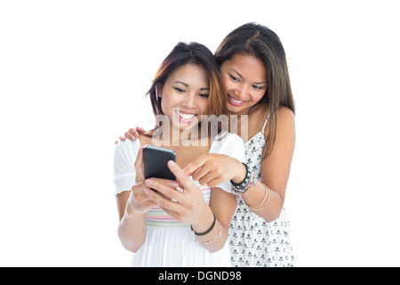 Deux jeunes sœurs using smartphone Banque D'Images