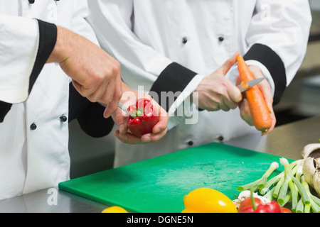Close up of two chefs cutting vegetables Banque D'Images