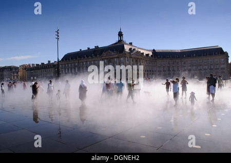 Les gens qui marchent dans la pulvérisation des mots plus grand miroir d'eau à la place de la Bourse, Bordeaux, France Banque D'Images