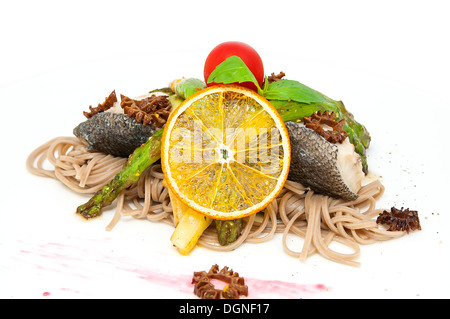 Du poisson cuit au four avec des spaghetti et les champignons et les légumes Banque D'Images