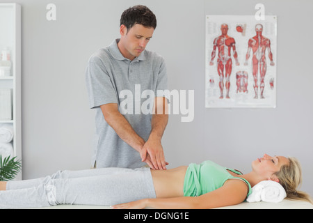 Physiotherapist examining patients bassin Banque D'Images